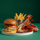Burger and Lobster combo on a plate in front of a green background