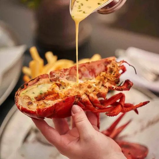 Sauce being poured on a lobster